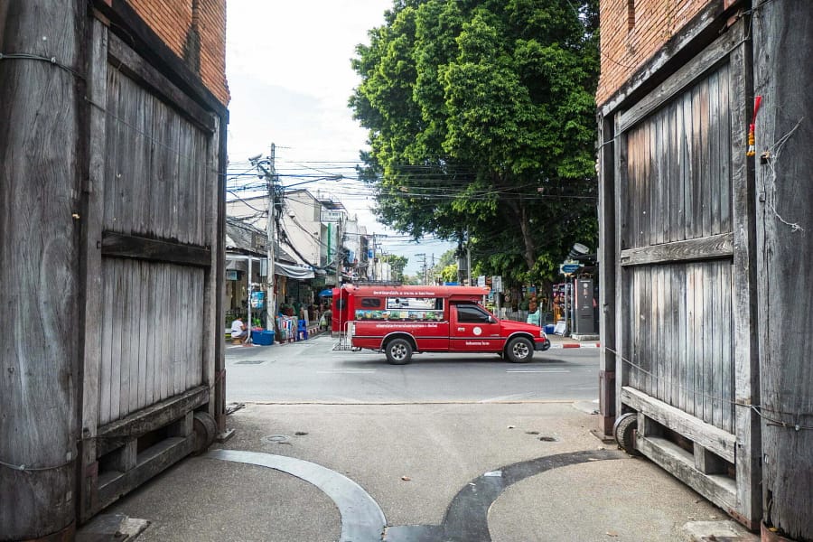 songthaew rouge passant devant porte tha phae gate chiang mai